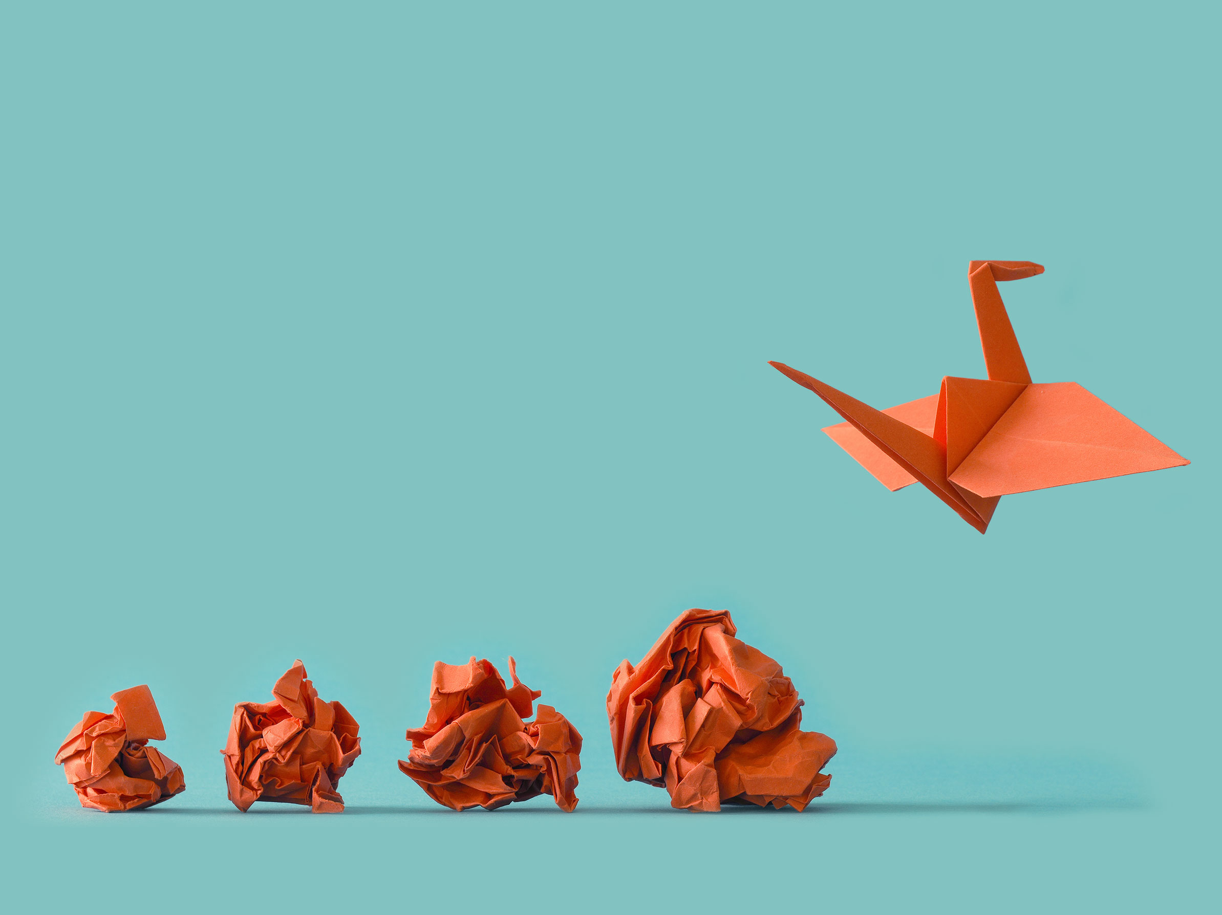 Onnistunutta muutosprosessia kuvaava origami-lintu nousee siivilleen ja symboloi kasvua.